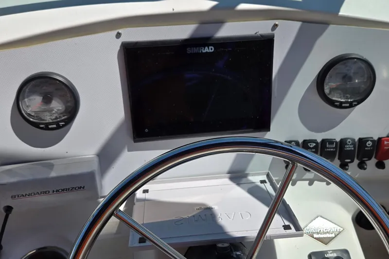 Slide: The Image of 2006 Boston Whaler 205 Conquest boat on trailer, under a partly cloudy sky. - 10