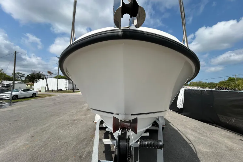 Slide: The Image of 2006 Boston Whaler 205 Conquest boat on trailer, viewed from the front under a cloudy sky. - 13