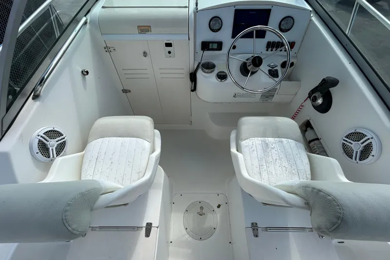 Slide: The Image of 2006 Boston Whaler 205 Conquest cockpit with steering wheel, gauges, and cushioned seats. - 19