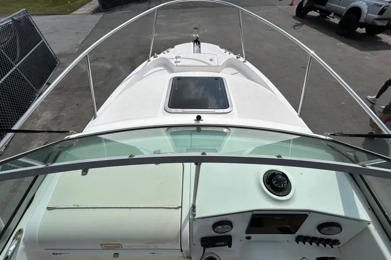 Slide: The Image of 2006 Boston Whaler 205 Conquest boat cockpit view with windshield and dashboard controls. - 23