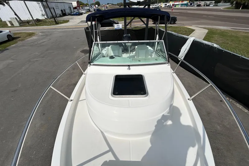 Slide: The Image of 2006 Boston Whaler 205 Conquest boat with windshield and canopy, parked outdoors. - 27