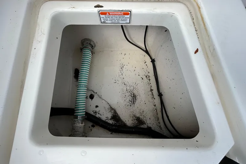 Slide: The Image of Storage compartment of a 2006 Boston Whaler 205 Conquest boat, showing hoses and wiring. - 43