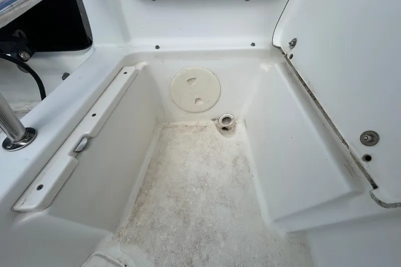 Slide: The Image of 2006 Boston Whaler 205 Conquest boat interior, showing storage compartment and drainage. - 46