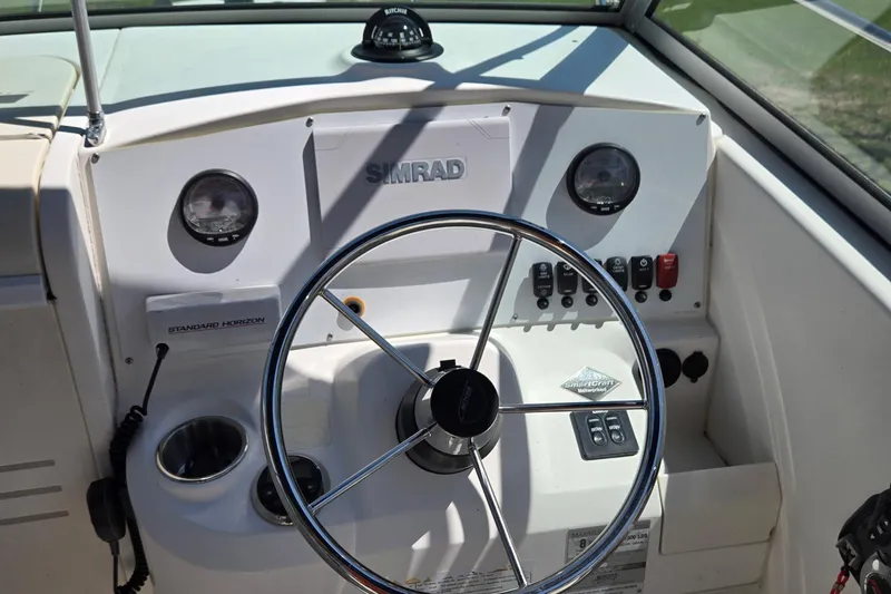 Slide: The Image of 2006 Boston Whaler 205 Conquest boat on trailer with Mercury engine, parked outdoors. - 9