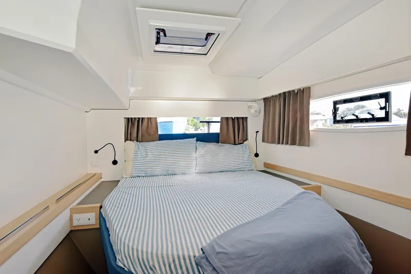 Slide: The Image of Cozy cabin interior of 2024 Fountaine Pajot Astrea 42 with striped bedding and natural light. - 31