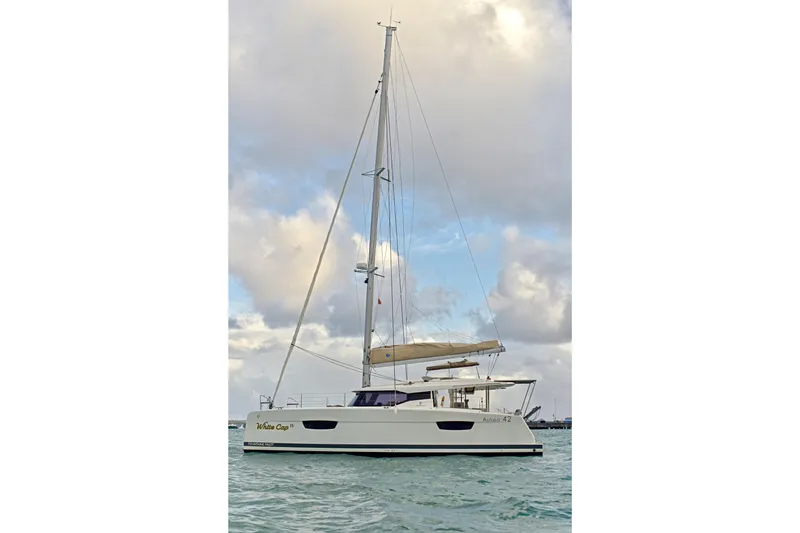 Slide: The Image of 2024 Fountaine Pajot Astrea 42 catamaran sailing on calm waters under a cloudy sky. - 2