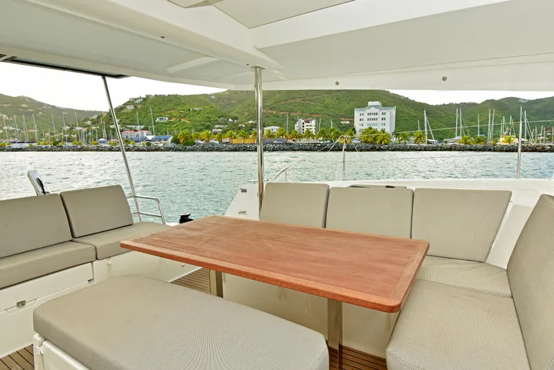 Slide: The Image of Spacious deck seating on 2024 Fountaine Pajot Astrea 42 catamaran with scenic marina view. - 6