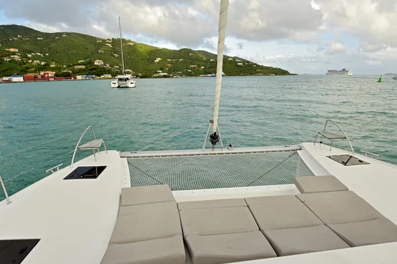 Slide: The Image of 2024 Fountaine Pajot Astrea 42 catamaran with scenic ocean view and lush green hills. - 8
