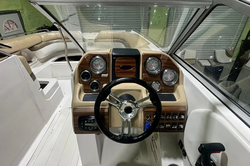 Slide: The Image of 2014 Starcraft Crossover 230 SCX IO boat dashboard with gauges and steering wheel. - 11