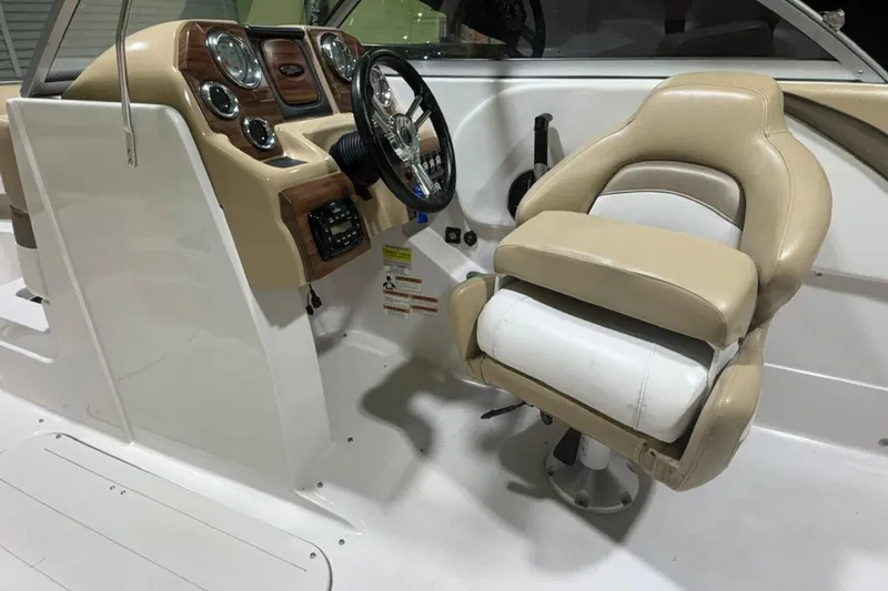 Slide: The Image of 2014 Starcraft Crossover 230 SCX IO boat interior with beige captain's chair and control panel. - 12