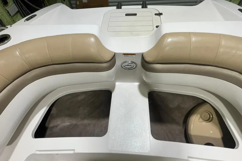 Slide: The Image of 2014 Starcraft Crossover 230 SCX IO boat interior with beige seating and storage compartments. - 17