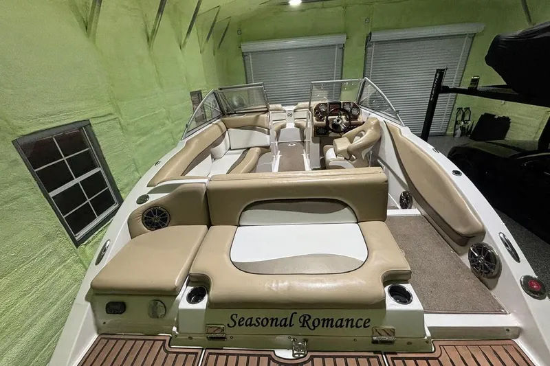 Slide: The Image of 2014 Starcraft Crossover 230 SCX IO boat with beige seating, stored indoors. - 18