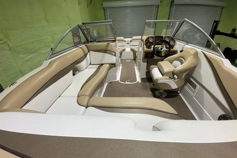 Slide: The Image of 2014 Starcraft Crossover 230 SCX IO boat interior with beige seating and modern dashboard. - 19