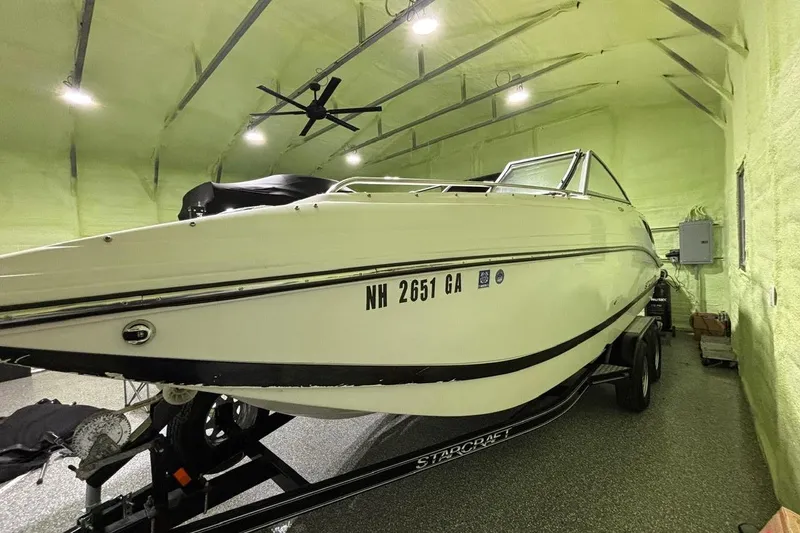 Slide: The Image of 2014 Starcraft Crossover 230 SCX IO boat in a spacious indoor storage facility. - 5