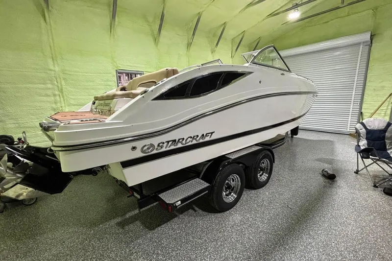 Slide: The Image of 2014 Starcraft Crossover 230 SCX IO boat on trailer in indoor storage. - 6