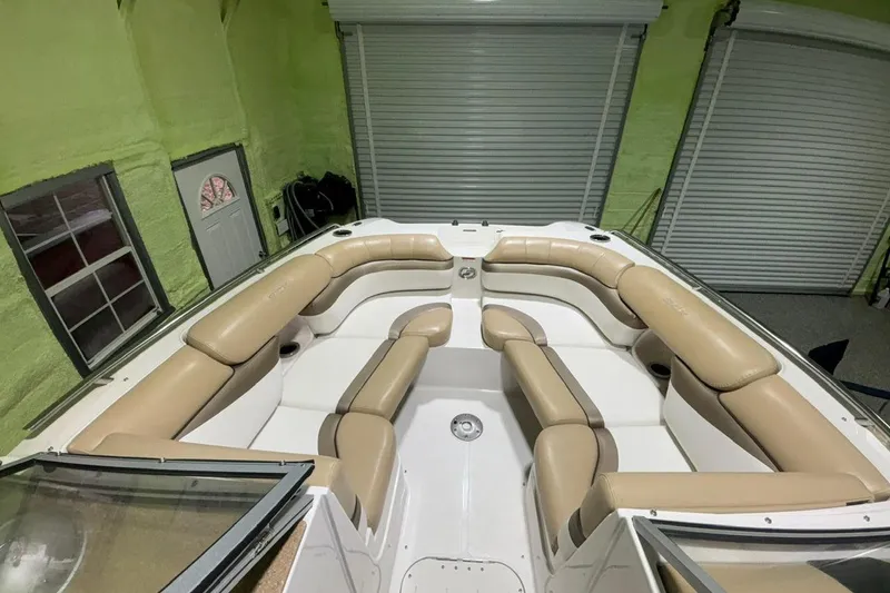 Slide: The Image of 2014 Starcraft Crossover 230 SCX IO boat interior with beige seating in a garage. - 9