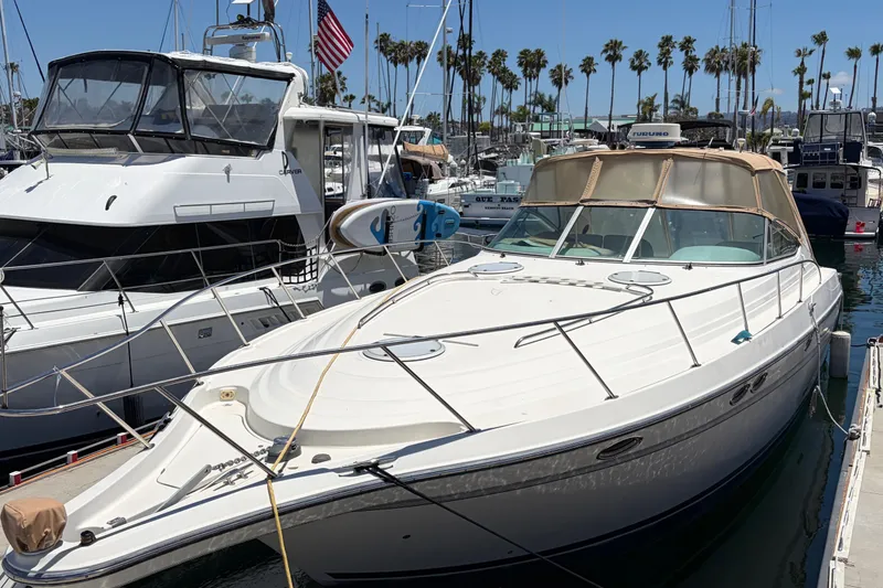 Slide: The Image of 1996 Maxum 3700 SCR yacht docked in marina, surrounded by other boats and palm trees. - 2