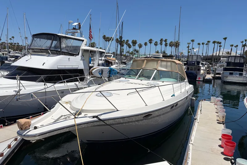 Slide: The Image of 1996 Maxum 3700 SCR yacht docked in a marina under clear blue skies. - 3