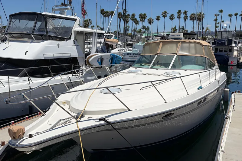 Slide: The Image of 1996 Maxum 3700 SCR yacht docked at marina with palm trees in background. - 5