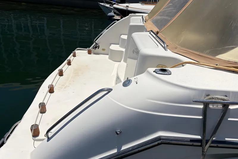 Slide: The Image of 1996 Maxum 3700 SCR boat deck with railing and seating, docked on calm water. - 6