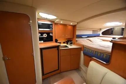 Slide: The Image of 2004 Cruisers 320 Express cabin interior with kitchenette and cozy sleeping area. - 10