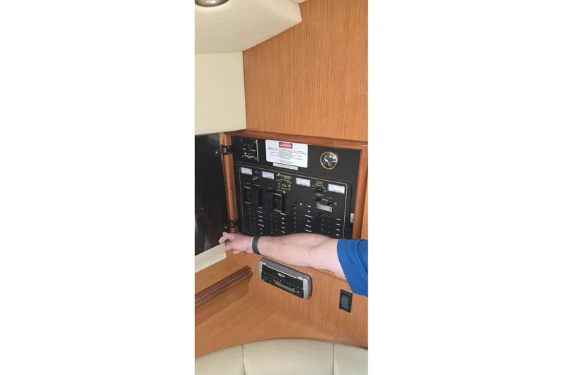 Slide: The Image of Control panel of 2004 Cruisers 320 Express yacht with a person adjusting switches. - 11
