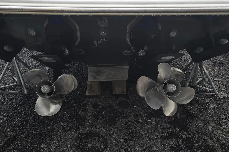 Slide: The Image of 2004 Cruisers 320 Express boat propellers on dry dock, supported by stands. - 16