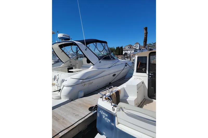 Slide: The Image of 2004 Cruisers 320 Express yacht docked at marina under clear blue sky. - 2