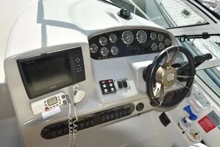 Slide: The Image of 2004 Cruisers 320 Express boat dashboard with steering wheel and navigation instruments. - 4