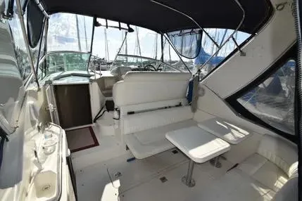 Slide: The Image of 2004 Cruisers 320 Express boat interior with seating and table, under canopy. - 5