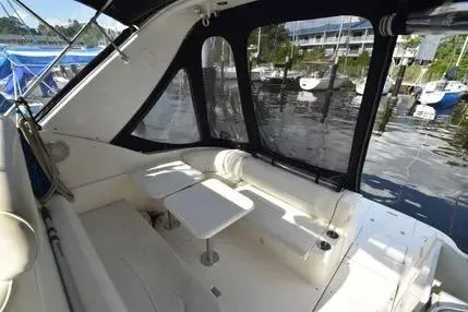 Slide: The Image of 2004 Cruisers 320 Express yacht interior with seating and table, docked at marina. - 7
