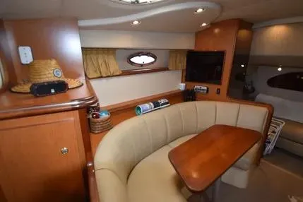 Slide: The Image of 2004 Cruisers 320 Express yacht interior with cozy seating and wooden table. - 8