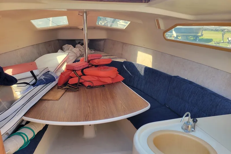 Slide: The Image of Interior of a 2002 Hunter 260 sailboat with table, seating, and life jackets. - 2