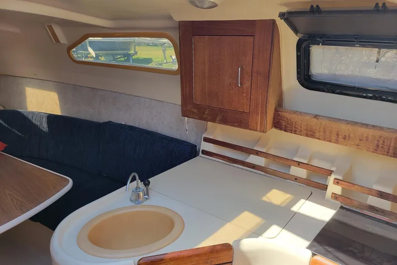 Slide: The Image of Interior of a 2002 Hunter 260 sailboat with seating, table, and kitchenette. - 4
