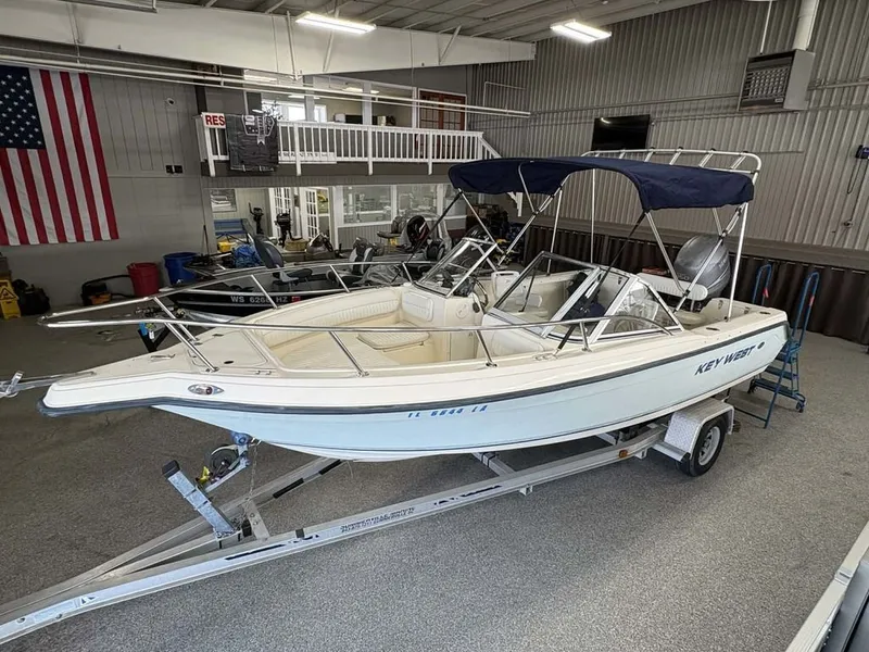 The Image of 2004 Key West 200 DC boat in a showroom on a trailer. - 1