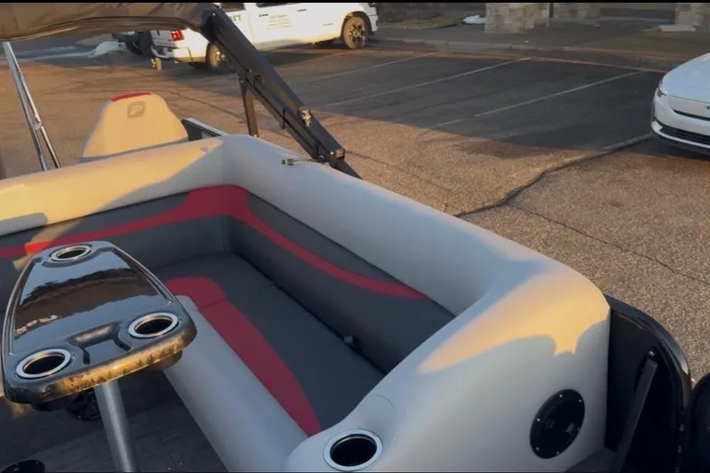 Slide: The Image of 2026 Princecraft Ventura 224 boat interior with seating and cup holders in a parking lot. - 17