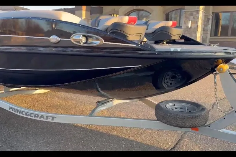 Slide: The Image of 2026 Princecraft Ventura 224 boat on trailer, sleek black design, parked outdoors. - 4