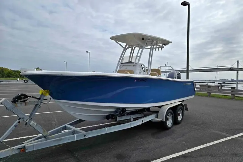 The Image of 2023 Sportsman Open 232 Center Console boat on trailer in parking lot. - 0