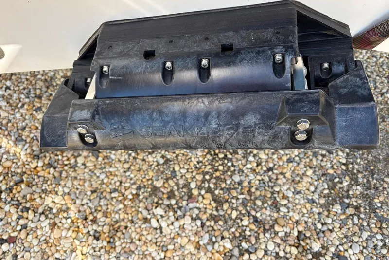 Slide: The Image of Close-up of a 2023 Sportsman Open 232 Center Console boat component on gravel. - 14