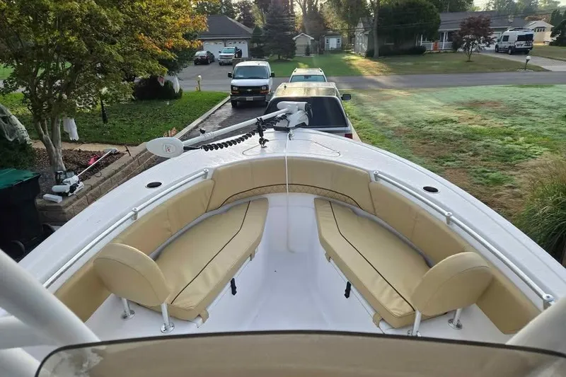 Slide: The Image of 2023 Sportsman Open 232 Center Console boat with beige seating, parked in a residential area. - 3