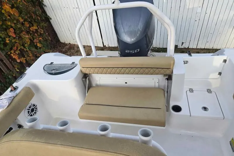 Slide: The Image of 2023 Sportsman Open 232 Center Console boat interior with seating and engine view. - 5
