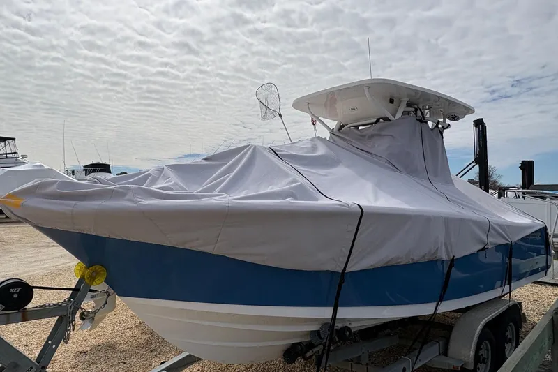 Slide: The Image of 2023 Sportsman Open 232 Center Console boat covered on trailer, under cloudy sky. - 8