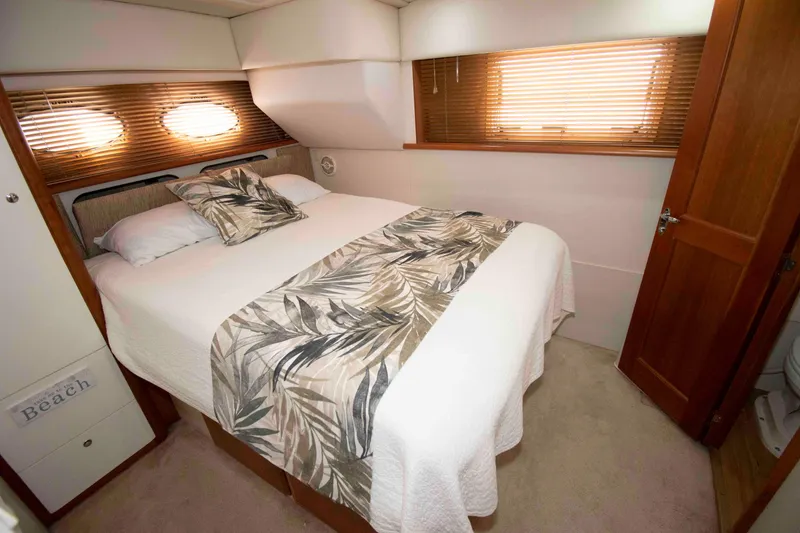 Slide: The Image of Luxurious bedroom interior of 2001 Silverton 392 Motor Yacht with elegant bedding and wooden accents. - 16