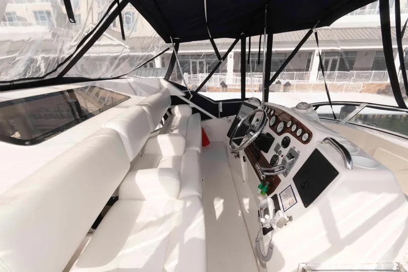 Slide: The Image of 2001 Silverton 392 Motor Yacht helm with white seating and control panel. - 5