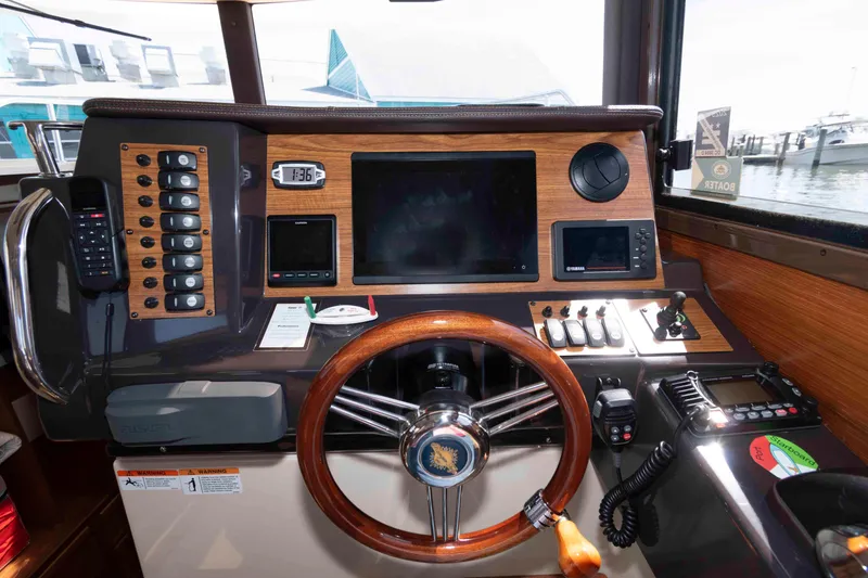 Slide: The Image of 2020 Ranger Tugs R-27 helm with wooden steering wheel and modern navigation controls. - 10