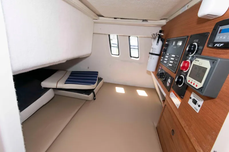 Slide: The Image of 2020 Ranger Tugs R-27 cabin interior with control panel and seating area. - 13
