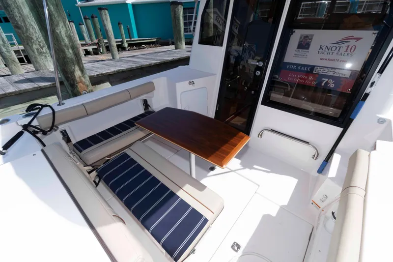 Slide: The Image of 2020 Ranger Tugs R-27 boat interior with seating and table, docked at marina. - 2