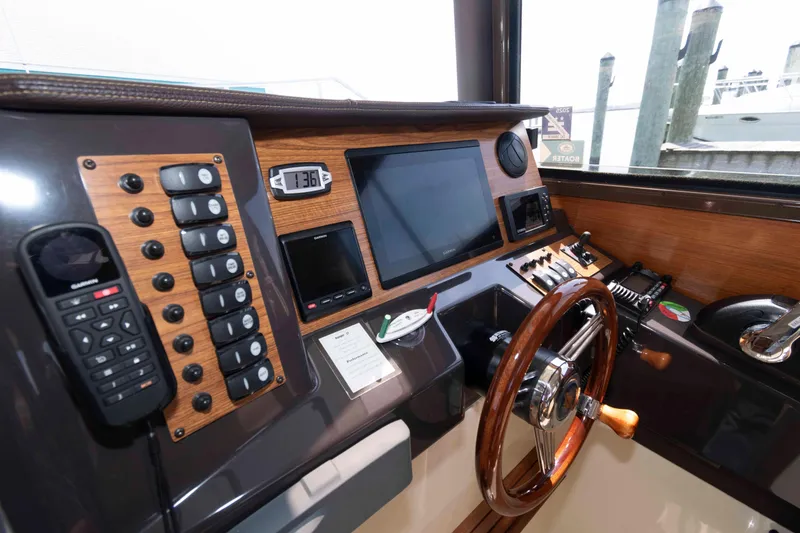 Slide: The Image of Cockpit of 2020 Ranger Tugs R-27 with navigation controls and wooden steering wheel. - 9