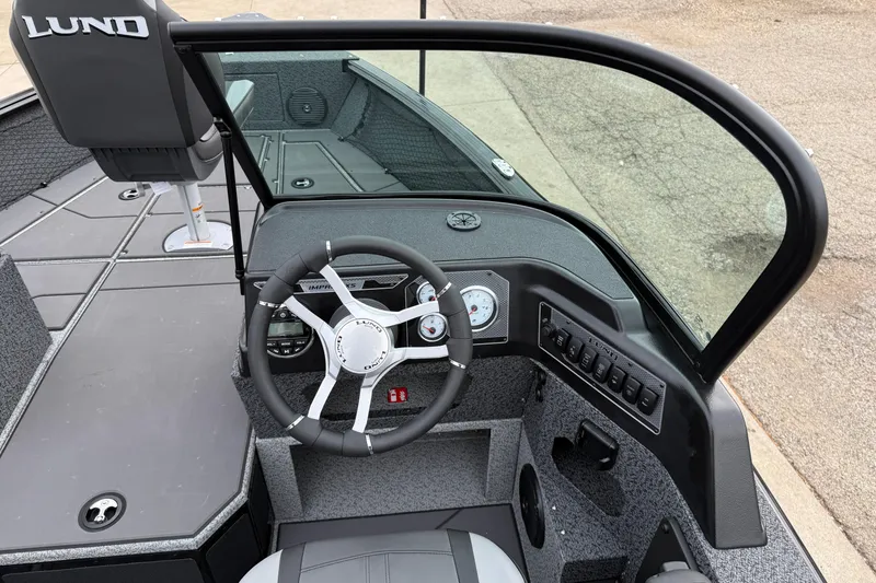 Slide: The Image of 2026 Lund 1775 Impact XS Sport boat cockpit with steering wheel and dashboard controls. - 15