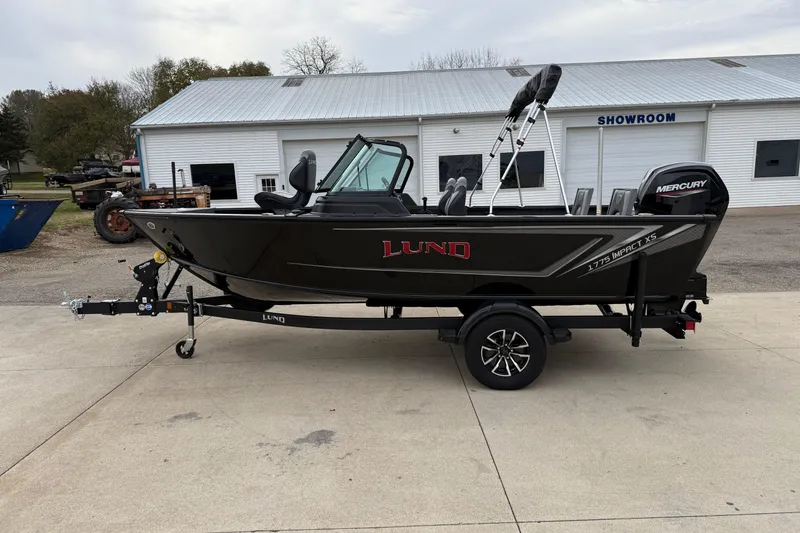Slide: The Image of 2026 Lund 1775 Impact XS Sport boat on trailer outside showroom. - 3